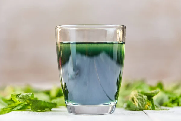 Green chlorophyll drink in glass with water Royalty Free Stock Images
