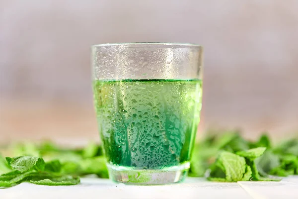 Mint chlorophyll minum dalam gelas dengan tetes air Stok Foto