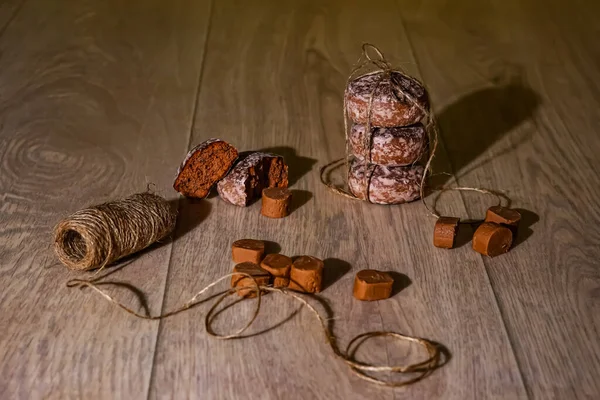 Güneş ışığındaki kokulu zencefilli kurabiyeler ve şekerler, açık ahşap bir yüzey üzerinde doğal kordonla. Güzel kompozisyon