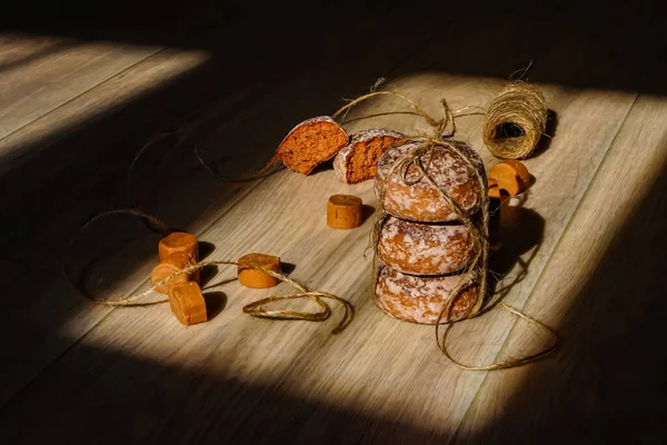 Güneş ışığındaki kokulu zencefilli kurabiyeler ve şekerler, açık ahşap bir yüzey üzerinde doğal kordonla. Güzel kompozisyon