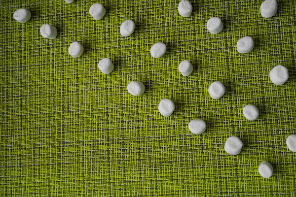 Birçok beyaz marşmelov yeşil ve sarı bir hasır peçeteye dizilmiştir. Alışılmadık bir tatlı fotoğrafı. Tatlı olarak lezzetli yemekler. Boşluğu kopyala