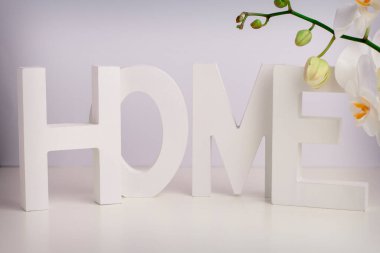 Tahta harfler ve beyaz orhid beyaz duvarın üzerinde beyaz bir masa üzerinde. Provence ev dekorasyonu. 