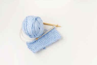 Yün iplikleri, tığ işi, örgü iğneleri, beyaz arka planda mavi renkli..