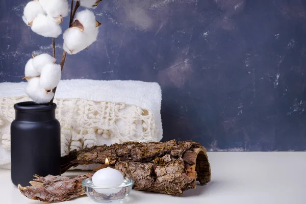 Spa konsepti geçmişi. Pamuk ağacı dalı ve yanan mumlu beyaz bir havlu.