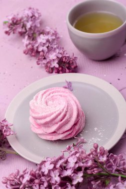 Ev yapımı marşmelov veya eflatun arkaplanlı bir fincan çay ile zephyr..