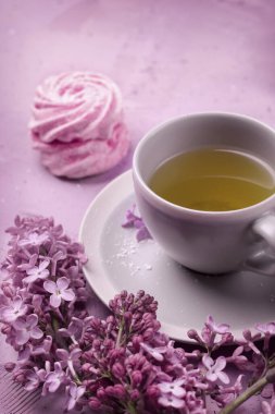 Bir fincan çay, ev yapımı marşmelov ve leylak. Romantik bahar. Seçici odak