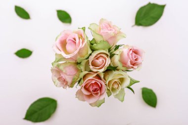 Pembe gül buketini beyaz vazoda cam güllerle kapatın..