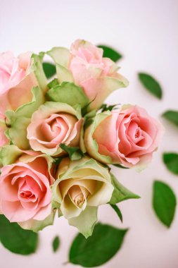 Pembe gül buketini beyaz vazoda cam güllerle kapatın..