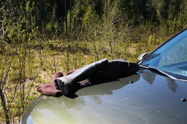 Lastik botlar arabanın üzerinde duruyor.