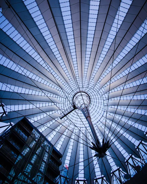 Gece vakti Potsdamer Platz, Berlin 'deki Sony Center' da aydınlanan kantilever kubbesinin ve bitişik binaların Zenith manzarası