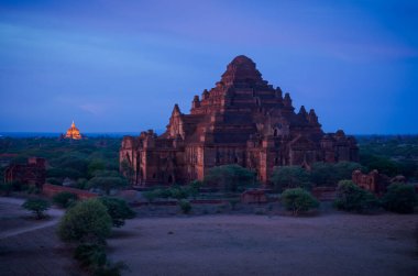 Tapınaklar vadisinin üstündeki bir tapınağın çatısından Unesco 'nun listelediği Bagan bölgesi gün batımında aydınlanır.