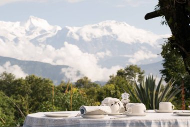 Himalayalar 'daki Annapurna sıradağları ile Pokhara, Nepal' deki lüks bir tatil köyünde kahvaltı masası.
