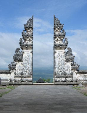 Geleneksel Balili bölünmüş kapı, Pura Cenneti Lempuyang Luhur tapınağı, granit taş oymaları ve panoramik manzaralı teras, Endonezya 'nın Bali adasındaki Batur volkanı ve bulutları ile