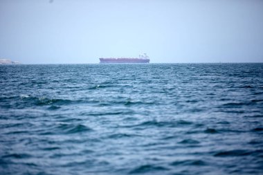 Mavi denizde ve mavi gökyüzünde bir petrol gemisi