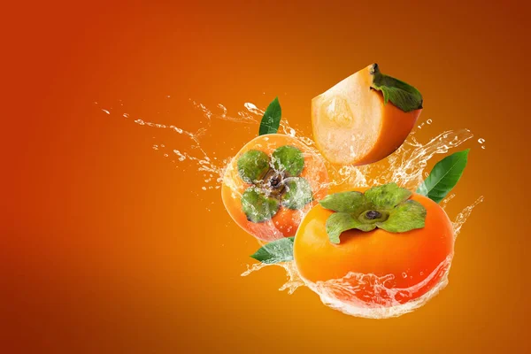 Wasser spritzt auf frischem Kaki auf orangefarbenem Hintergrund — Stockfoto