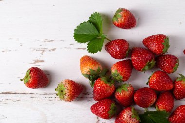 Beyaz ahşap bir masa üzerinde taze çilek