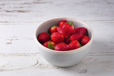 Beyaz ahşap bir masa üzerinde taze çilek