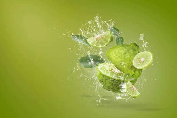 Water splashing on Bergamot fruit on green background — 图库照片