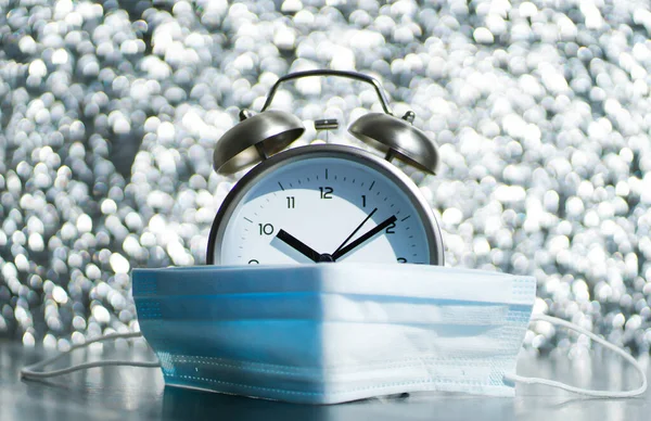 Relógio Alarme Velho Máscara Médica Fundo Prateado Foco Turvo — Fotografia de Stock