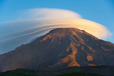 Koryak volcano and lenticular cloud, morning, Kamchatka.  clipart