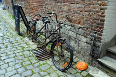 Paslı eski bir bisiklet, tuğla bir duvar dikmiş. Durbuymuş. Belçika