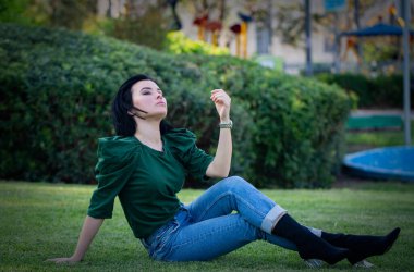 Saçlarını arkaya atan güzel bir kadın. Çekici esmer beyaz kadın gezginin yakın portresi rüzgarlı saçlı, dışarıda hayal kuruyor, baharda ya da yazın, parkta. Yaşam biçimi.