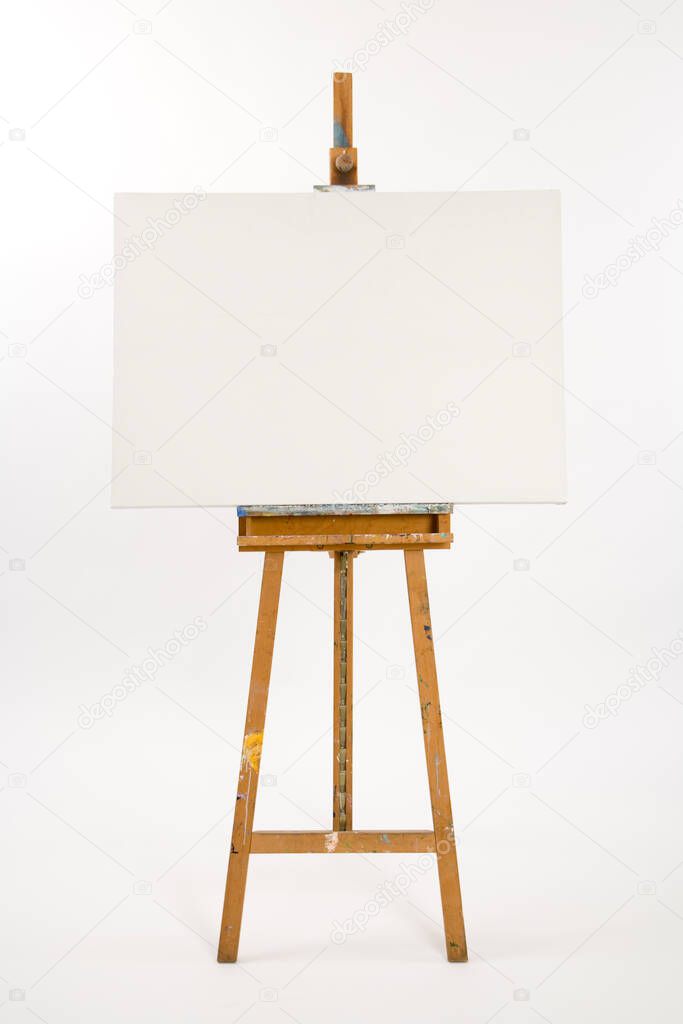 Well used artists easel with blank canvas waiting