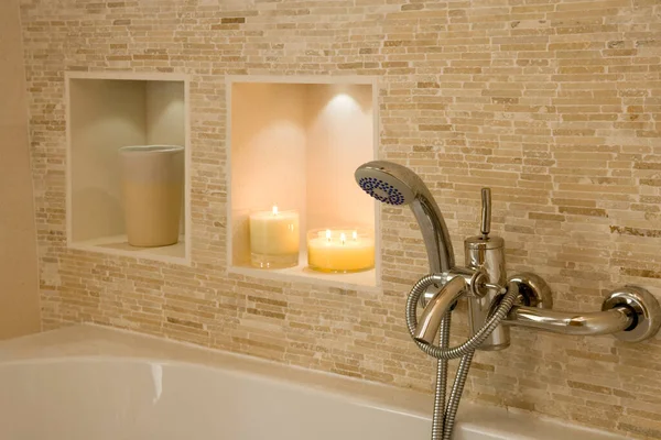 Banyo başlığı ve musluklar mumlarla dolu.