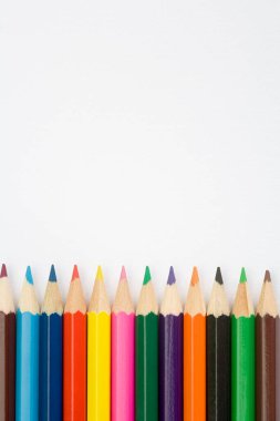 Düz beyaz desenli arka planda çocuk kalemleri boyuyor.