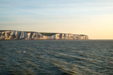 Early morning spring sunshine as a cross channel ferry passes the white cliffs of Dover, Kent, UK heading for Calais, France clipart