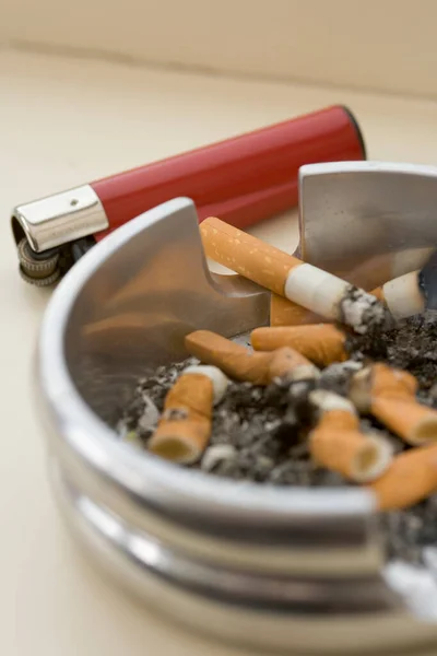 tabaco de liar, cenicero, boquillas y un cigarro encendido foto de Stock
