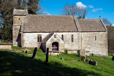Cotswolds, Gloucestershire, İngiltere 'deki Duntisbourne Rouse' daki eski güzel kilisede bahar güneşi.