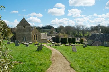 Cotswolds, Gloucestershire, İngiltere 'deki Duntisbourne Abbots' taki eski güzel kilisede bahar güneşi.