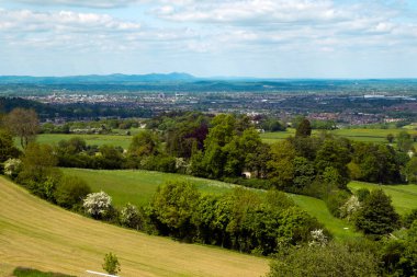 Uzakta Malvern Tepeleri ile Severn Vadisi 'ndeki Gloucester şehrinin geniş manzarası. Cotswolds, Gloucestershire, İngiltere 'nin batı kıyısındaki Cud Hill Common' dan.