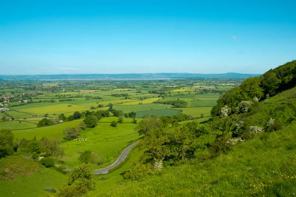 Coaley Tepesi Piknik Alanı ve Viewpoint, Gloucestershire, Birleşik Krallık 'ta yer alan Coaley Tepesi Piknik Alanı' nda, önü dolambaçlı bir yolu olan tarlaların üzerinde Severn Nehri ve Dean Ormanı 'na doğru geniş bir bakış açısı var.