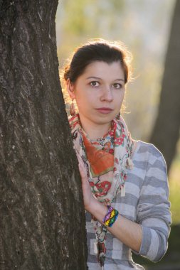 Genç kız dışarıda poz veriyor.