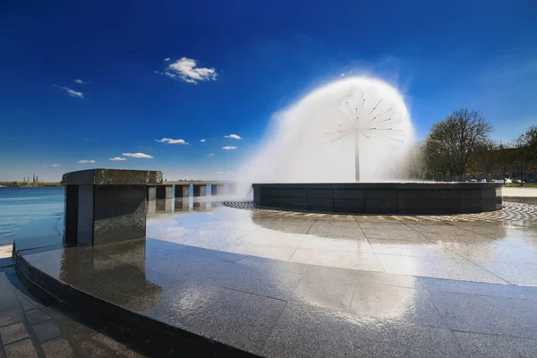 Belle fontaine avec reflet contre le ciel bleu avec des nuages I — Photo