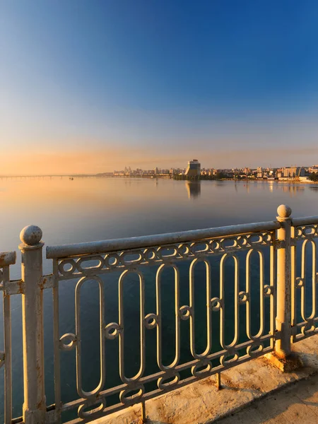 Hermosa vista desde el puente a la ciudad al amanecer en los rayos del sol naciente —  Fotos de Stock