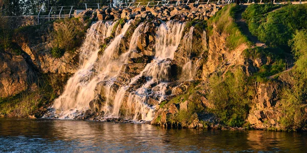Beautiful waterfall at sunset in the rays of the setting sun I