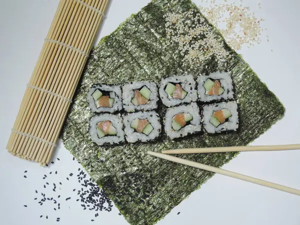 寿司卷与鲑鱼 芝麻籽 黄瓜在垫子上 — 图库照片