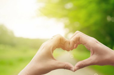 Eller şekil doğa yeşil bokeh güneş ışık parlama üzerinde kalp ve yaprak arka plan bulanıklık.