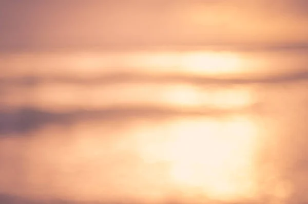 Verschwimmen tropischen Sonnenuntergang Strand mit Bokeh Sonne Licht Welle abstrakten Hintergrund. — Stockfoto