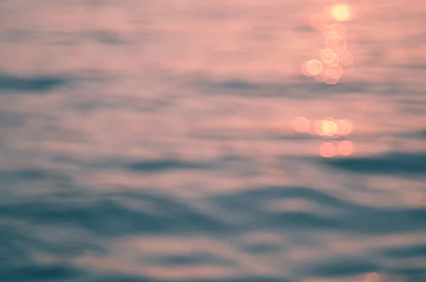 Verschwimmen tropischen Sonnenuntergang Strand mit Bokeh Sonne Licht Welle abstrakten Hintergrund. — Stockfoto