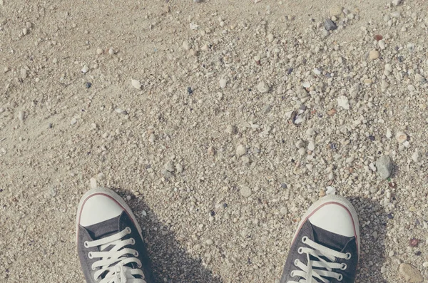 stock image Top view of shoes on tropical wave beach.