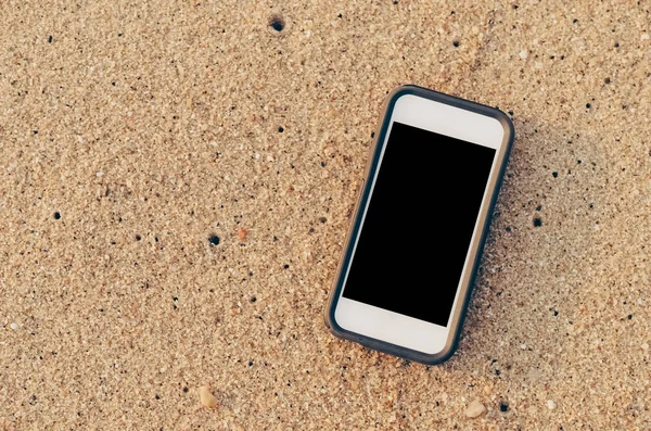 Smart phone on sand beach texture background. — Stock Photo, Image