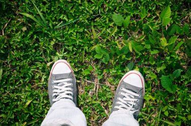 Doğa yeşil çimen, selfie üzerinde ayakkabı ve mavi jean üstten görünüm. 