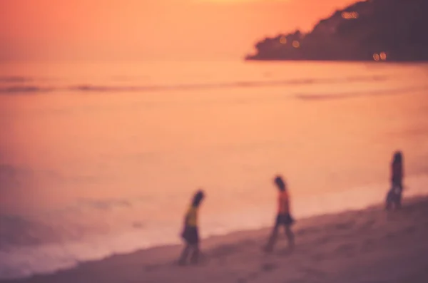 Unschärfe Kinder spielen am tropischen Sonnenuntergang Strand. — Stockfoto