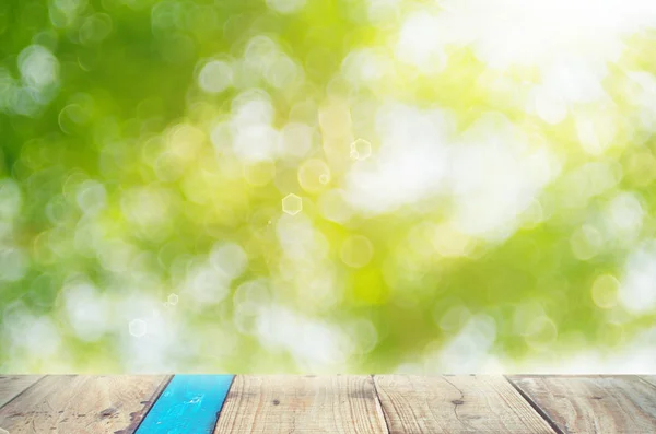 Oskärpa grön natur bokeh med solljus på kopia utrymme tomma gamla bord av trä abstrakt bakgrund. — Stockfoto