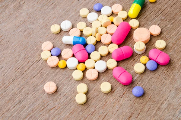 Close up pílula medicina colorida cápsula sobre fundo de madeira . — Fotografia de Stock