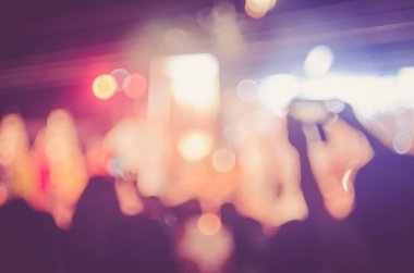 Gece açık konserinde renkli bokeh arka plan ile akıllı telefon alan insanlar bulanıklık.